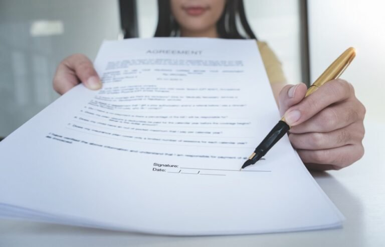 une personne signant un contrat de travail